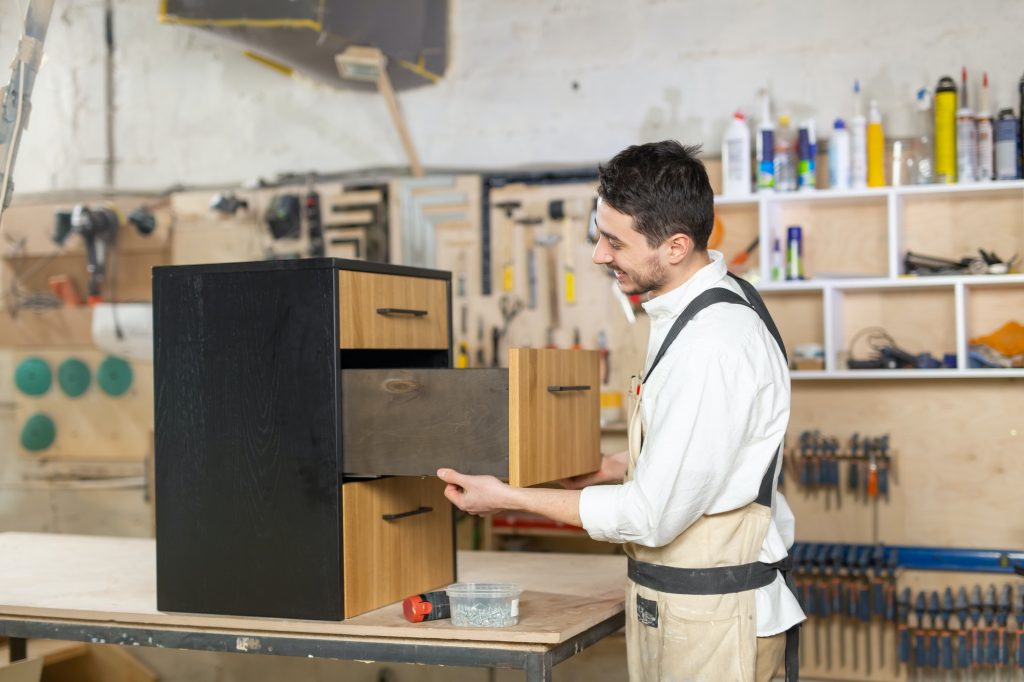 Small-Sized Companies concept - man working at furniture production